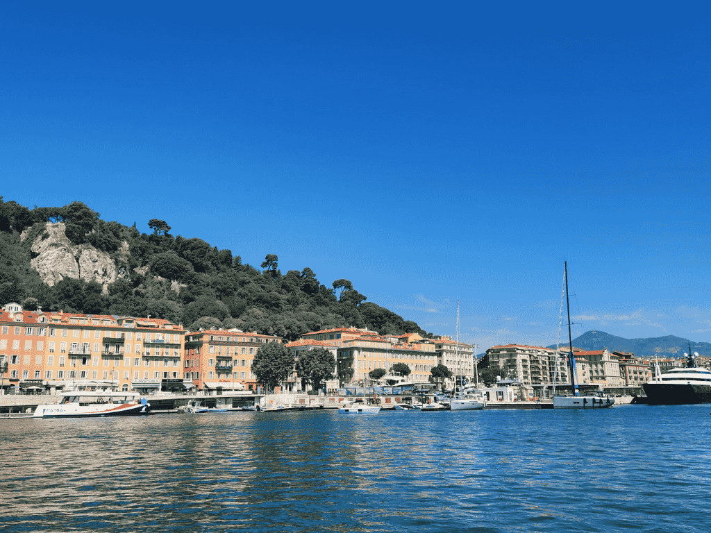 quais du port lympia à nice avec immeubles, bateaux et colline en arrière plan