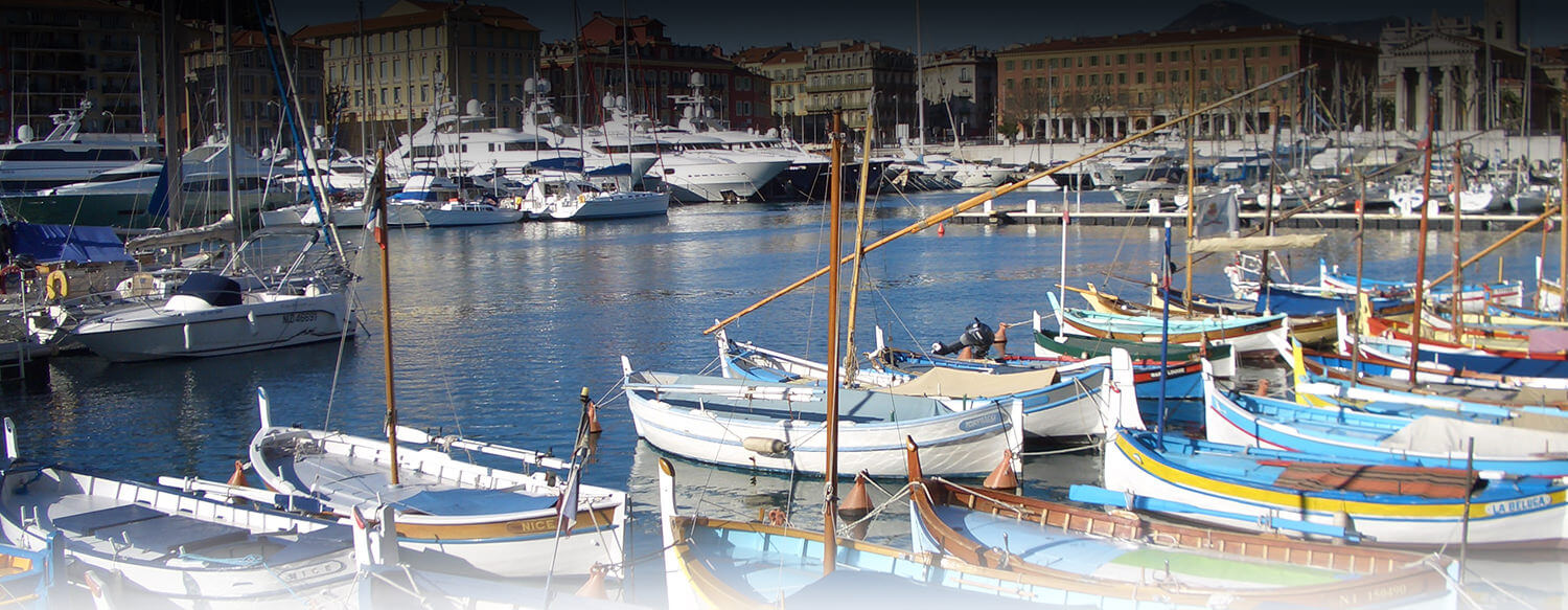 bateaux traditionnels et yachts dans le port de nice avec immeubles en arrière plan